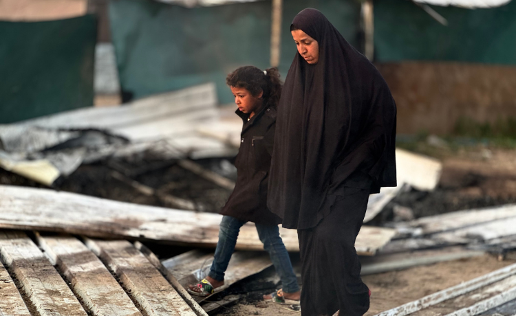 A woman walks through the destroyed Khan Younis displacement camp, amid a dire shortage of hygiene supplies. © UNFPA Palestine/Media Clinic 