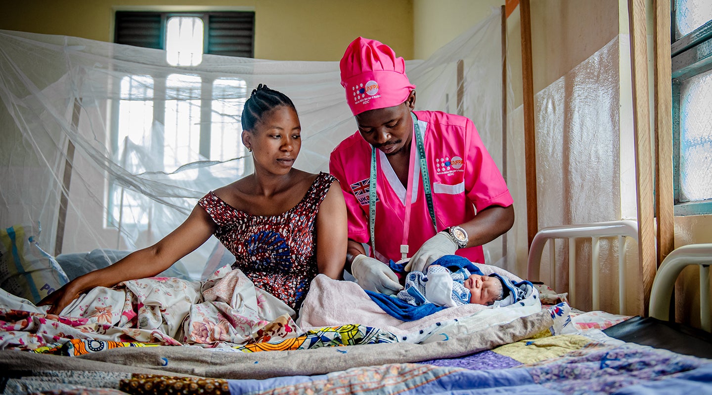 Midwife Obedi Lumoo Bikoma attends to a woman and her newborn in conflict-affected Goma, in North Kivu Province. 