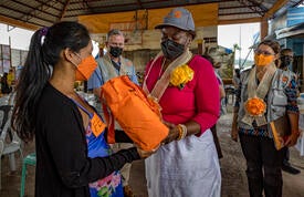 Dr. Kanem hands an orange dignity kit to a young women